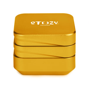 STEEZY® 4+1 | High Class Grinder | 63mm | 4-teilig Kräutermühle | quadratisch | CNC-gefräste Aluminiumlegierung | Neodym Magnetverschluss | Inklusive Pinsel & Klopfband  "Sunset Gold"