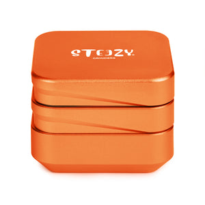 STEEZY® 4+1 | High-Class Grinder | 63mm | 4-piece herb grinder | square | CNC-machined aluminum alloy | Neodymium magnetic closure | Includes brush & tapping band "Blazing Orange"